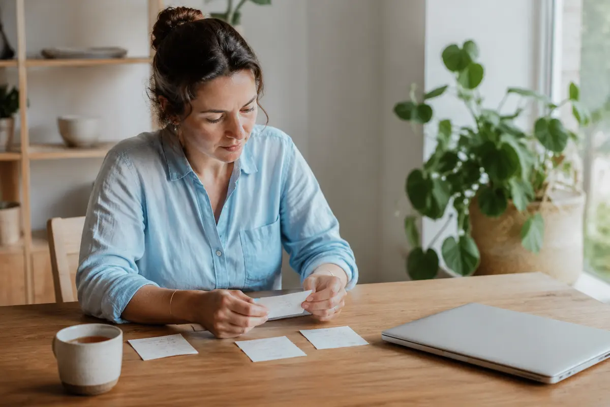 Femme triant ses priorités sur des notes à son bureau
